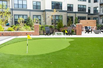 A putting green in front of an apartment